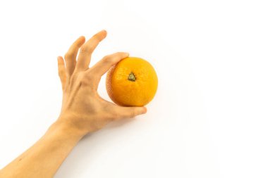 Beyaz arka planda taze portakalı tutan el.