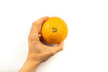Beyaz arka planda taze portakalı tutan el.