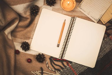 Kış konforu ve ruh hali, mum ışığında ekoseyle ilgili notlar için bir defter, uzay fotoğrafını kopyala