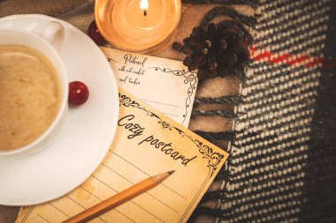 Romantik bir mektup, mum ışığında ve ekose üzerinde, evde konfor fotoğrafı olan kalemle dolu bir kartpostal.