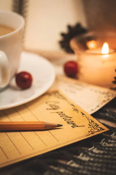 Romantic letter, greetings postcard with pencil, evening by candlelight and on plaids, warm and cozy tones