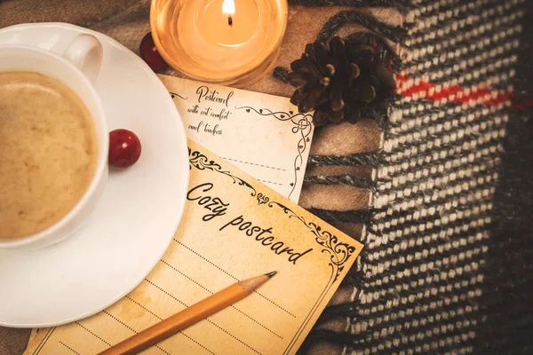 Romantik bir mektup, mum ışığında ve ekose üzerinde, evde konfor fotoğrafı olan kalemle dolu bir kartpostal.