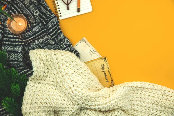 Acogedor fondo amarillo de invierno y otoño con suéter de lana y punto, postales y velas, planas y vista superior — Foto de Stock