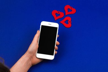 Sevgililer Günü 'nde akıllı telefonla sosyal medya etkileşimi, kalp şeklinde yeni bilgilendirme, kadın eli. Yüksek kalite fotoğraf