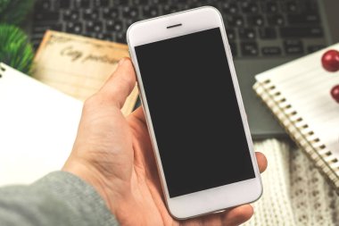 Kış tatilinde iş konsepti, dekorasyon fotoğrafının arka planında siyah beyaz akıllı telefon tutan adam.