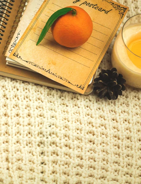 Winter background with knitted sweaters, books and tangerines, home comfort concept on cozy holidays, copy space photo