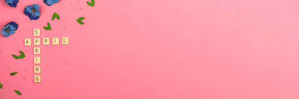 4月レタリングフラットレイコンセプト 春の背景 トップビュー ピンクの色と装飾花 コピースペースの写真付きバナー — ストック写真