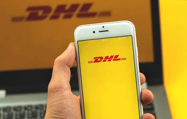 Kharkov, Ukrayna - 22 Şubat 2021: Apple akıllı telefonu ekranında DHL uygulaması, nakliye şirketinin logosu, arka plan fotoğrafı