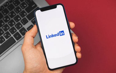 Kharkov, Ukrayna - 9 Mart 2021: Adam LinkedIn uygulaması açık akıllı telefonu tutuyor
