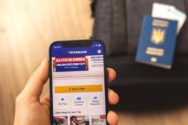 Kharkov, Ukrayna - 9 Mart 2021: Adam cep telefonundaki Ryanair uygulaması ve seyahat konseptini kullanarak uçak bileti sipariş edecek