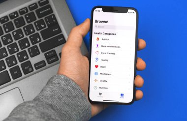 Kharkov, Ukrayna - 9 Mart 2021: Apple iPhone 12 mini uygulamasında Apple Health uygulamasını kullanan adam