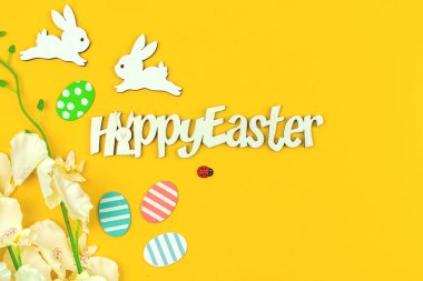 Mutlu Paskalyalar, metin ve paskalya yumurtaları, tavşan ve çiçeklerle dolu bir geçmiş.