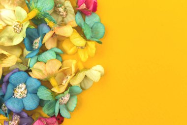 Sarı kağıtta renkli çiçekler olan bahar çiçekleri.
