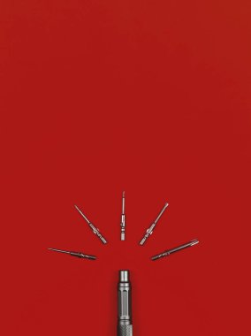 Kırmızı zemin üzerinde bit ve tornavida kümesi, üst görünüm, uzay fotoğrafını kopyala