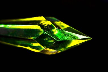 Siyah arkaplanda yeşil ve sarı mücevher taşından yakın çekim stüdyo fotoğrafı.