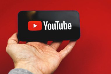 Kharkov, Ukrayna - 24 Mart 2021: Youtube logosu olan bir adam cep telefonunu elinde tutuyor