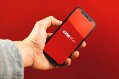 Kharkov, Ukrayna - 24 Mart 2021: BBC Haber uygulama logosu, kırmızı arka planda haber uygulamalı cep telefonu