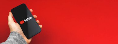 Kharkov, Ukrayna - 24 Mart 2021: Youtube uygulaması, afişi ve uzay fotoğrafını kullanan kişi