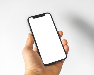 Kharkov, Ukrayna - 3 Nisan 2021: Apple iPhone 12 'yi elinde tutan adam, beyaz ekranlı