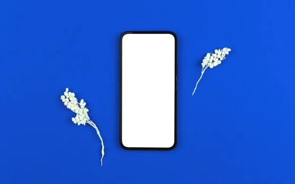 Blommig platt låg skärm mockup, smartphone med blank vit skärm på en bakgrund med torkad blomma, blå papper struktur — Stockfoto