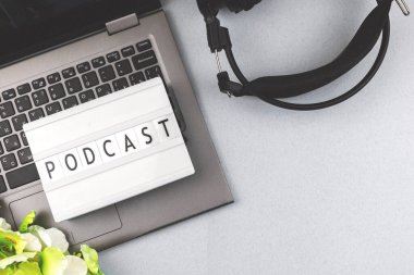 Podcast konsepti arka plan, düz yatak ve üst görünüm fotoğraf ışık kutusu ve mektuplar, ofis masasında kulaklık olan laptop