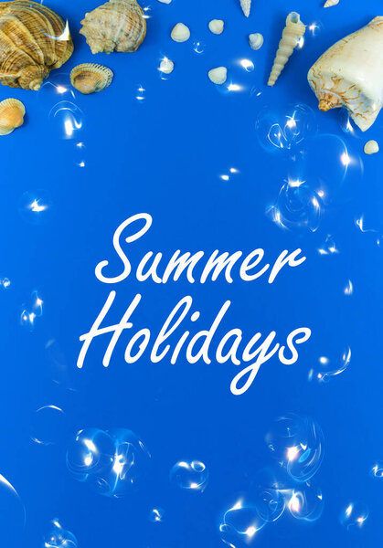 Summer holidays and vacation concept greeting card or postcard concept, blue background with seashells, top view photo