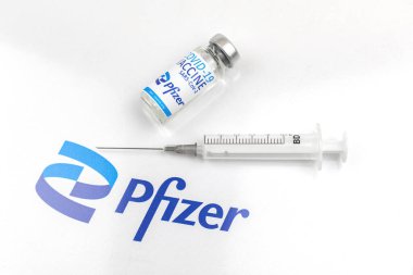 Kharkov, Ukraine - April 18, 2021: Coronavirus prevention and vaccination by using Pfizer vaccince vial and syringe, injection concept, white background photo