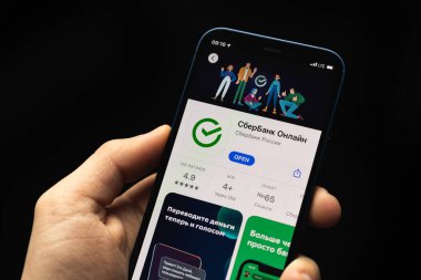 Kharkov, Ukrayna - 20 Nisan 2021: Sberbank uygulaması logo ve simgeyi kapat, adam Rus bankası ile akıllı telefon kullanıyor