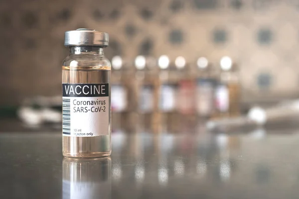 COVID-19 vaccine development and manufacture process, medical and hospital background, vaccination concept with label close up