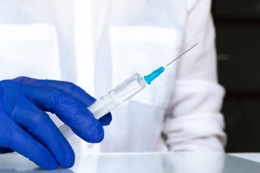 Beyaz önlüklü doktor, tıbbi şırınga, hastane geçmişi, mavi eldiven, iğne yakın