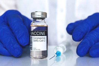 Tıbbi eldivenli doktor covid aşı şişesi, aşı geçmişi hastanede, aşı konsepti...