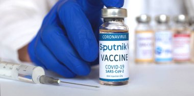 Kharkov, Ukrayna - 19 Nisan 2021: Sputnik V aşı şişesi elinde, Coronavirus 'a karşı aşı şişesi olan doktor, covid-19 aşı kavramı arka plan pankartı 