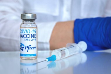 Kharkov, Ukrayna - 19 Nisan 2021: Pfizer aşı şişesi doktor masasında şırıngayla, kapatın