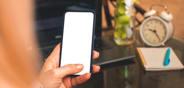 Kadın kullanımı cep telefonu modeli, kopyalama alanı olan boş beyaz ekran, rahat çalışma alanı kavramı 