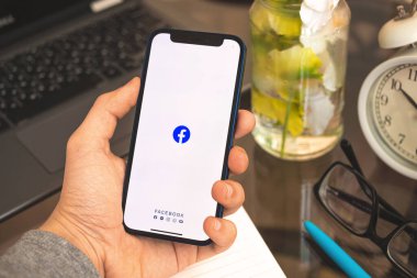 Kharkov, Ukrayna - 27 Nisan 2021: Apple iPhone ekranında Facebook logosu, adam sosyal ağ konsepti kullanıyor 