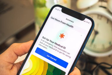 Kharkov, Ukrayna - 27 Nisan 2021: Adam Apple iPhone 'u tıbbi kimlik uygulaması ile kullanıyor, adam akıllı telefonu yakın plan çekiyor 