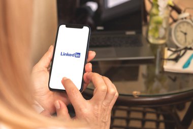 Kharkov, Ukrayna - 27 Nisan 2021: Kadın ekranda LinkedIn Uygulaması ile cep telefonu kullanıyor 