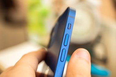 Kharkov, Ukrayna - 27 Nisan 2021: Apple iPhone 12 ses düğmesi kapat, yan sessizlik kaydıracı 