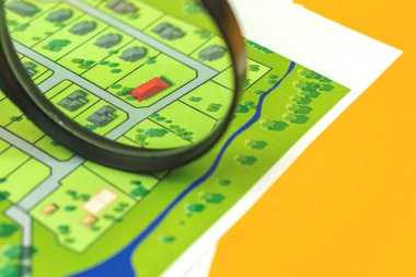 Ev yapımı konsept fotoğraf, büyüteç ve haritadaki ev için arsa seçiyorum.