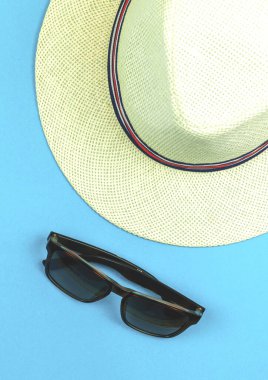 Yaz mavisi arka plan, hasır tropik şapka ve güneş gözlüğü seyahat için. 