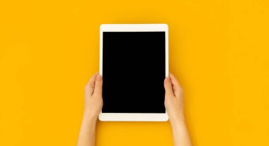 Kadın eli boş ekran, eğitim ve uygulama konsepti şablonu, parlak sarı arkaplan, üst görünüm ve kopyalama alanı ile dijital tablet modelini tutuyor 