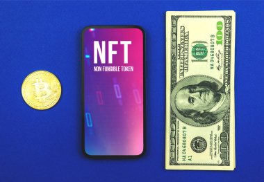 Kriptografik NFT, modern cep telefonu ekranında karşılanamayan sembol logosu, para ve kripto bitcoin ile ofis masası, kripto para ve teknoloji konsepti, üst görünüm. 
