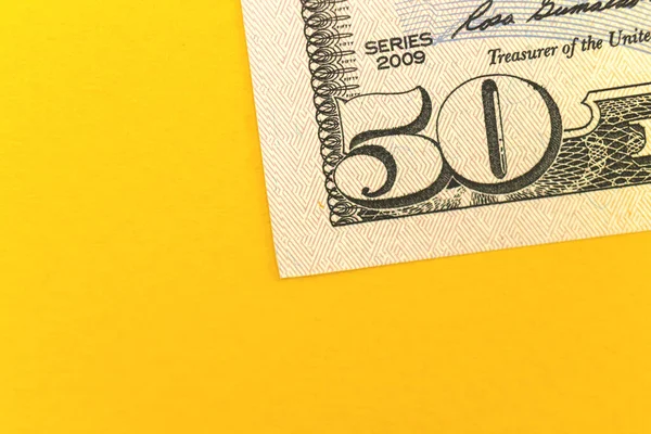 Deposit money with fifty dollar bills, office desktop with yellow background and copy space