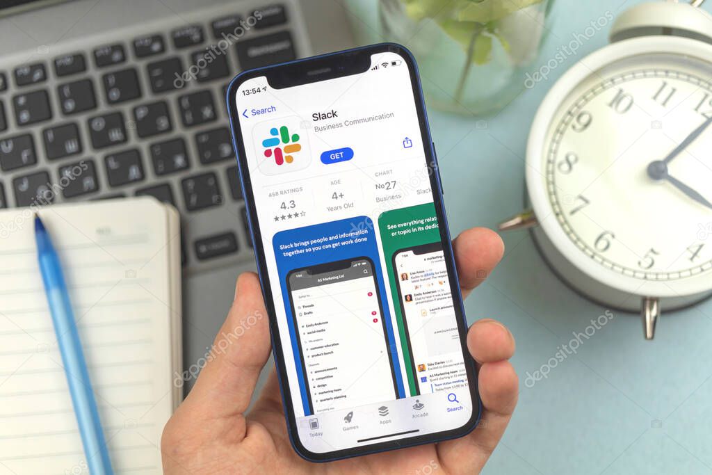 Kharkov, Ukraine - May 28, 2021: Man holds mobile phone with Slack app on the screen