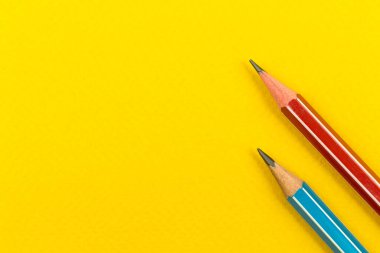 Okul malzemeleri, sarı bir masaüstü arka planında keskin kalemler, kopya alanı, üst görünüm, okul konseptine dönüş fotoğrafı.