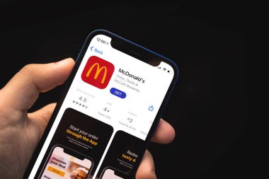 Kharkov, Ukrayna - 4 Haziran 2021: Cep telefonunda McDonald uygulaması kullanan adam