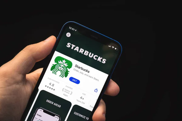 Charkow, Ukraine - 4. Juni 2021: Mann benutzt Starbucks-App, Handy in der Hand — Stockfoto