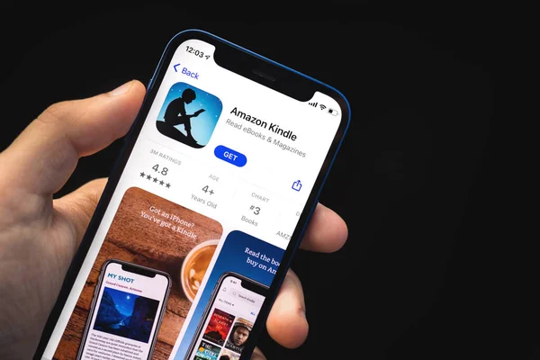 Kharkov, Ucrania - 4 de junio de 2021: Amazon kindle app, man holds mobile phone with application on the screen —  Fotos de Stock