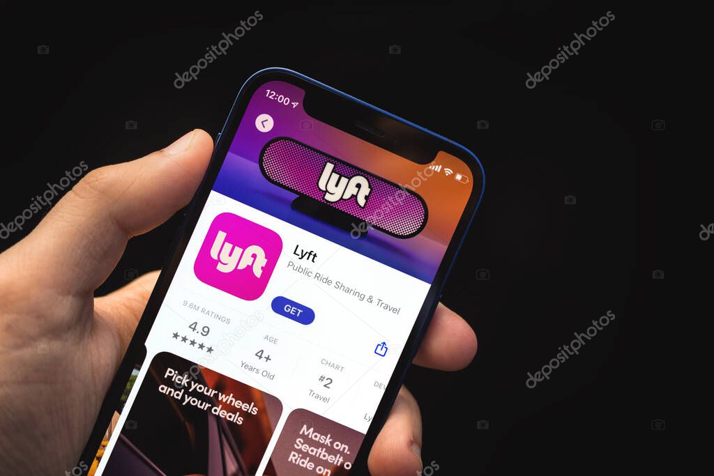 Kharkov, Ukraine - June 4, 2021: Man holds mobile phone and use Lyft app