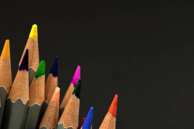 Sanat eseri renkli kalemler. Siyah arka plan ve okul kalemlerine yakın çekim. Boşluğu kopyala 